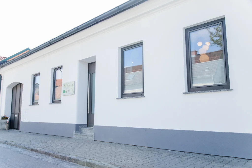 Hausfront mit weißer Fassade, Haustüre, Tor und Fensterrahmen sind dunkelgrau - Schlafen im Weinviertel