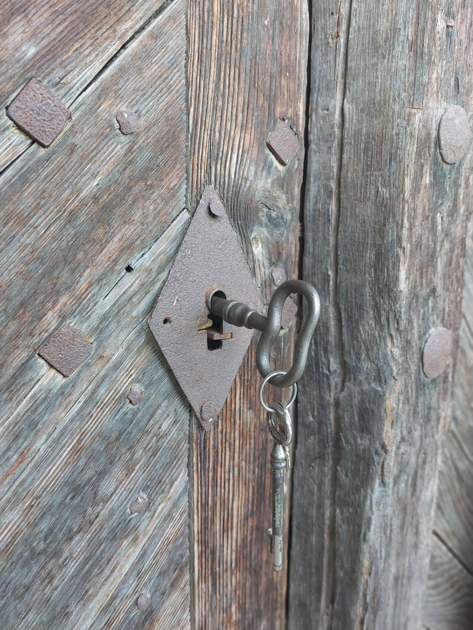 alte Holzkellertür mit einem eisernen eingesteckten Kellerschlüssel - Urlaub in Poysdorf
