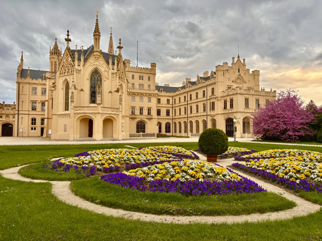 Außenansicht des Schloss Lednice und einen Blumenbeet in form eines Springbrunnen aufgebaut - Ausflugsziele im Weinviertel