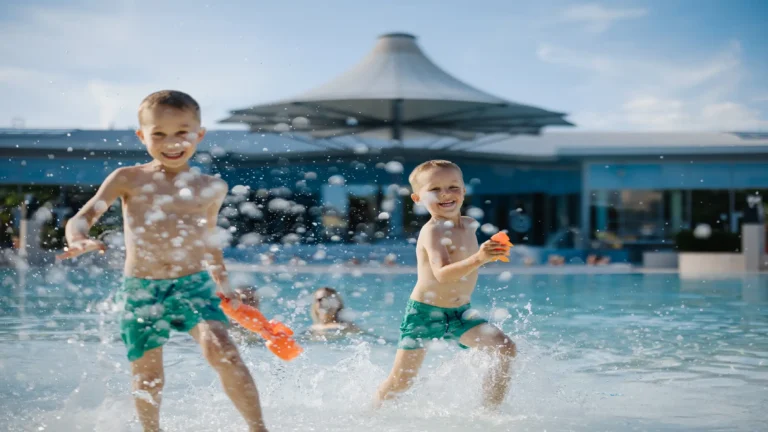 Zwei Kinder spielen im Wasserbecken und spritzen mit Wasser wild um sie herum - Ausflugsziele im Weinviertel